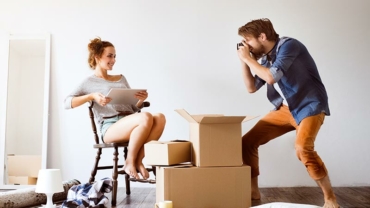 Young-couple-moving-in-new-house-taking-photos